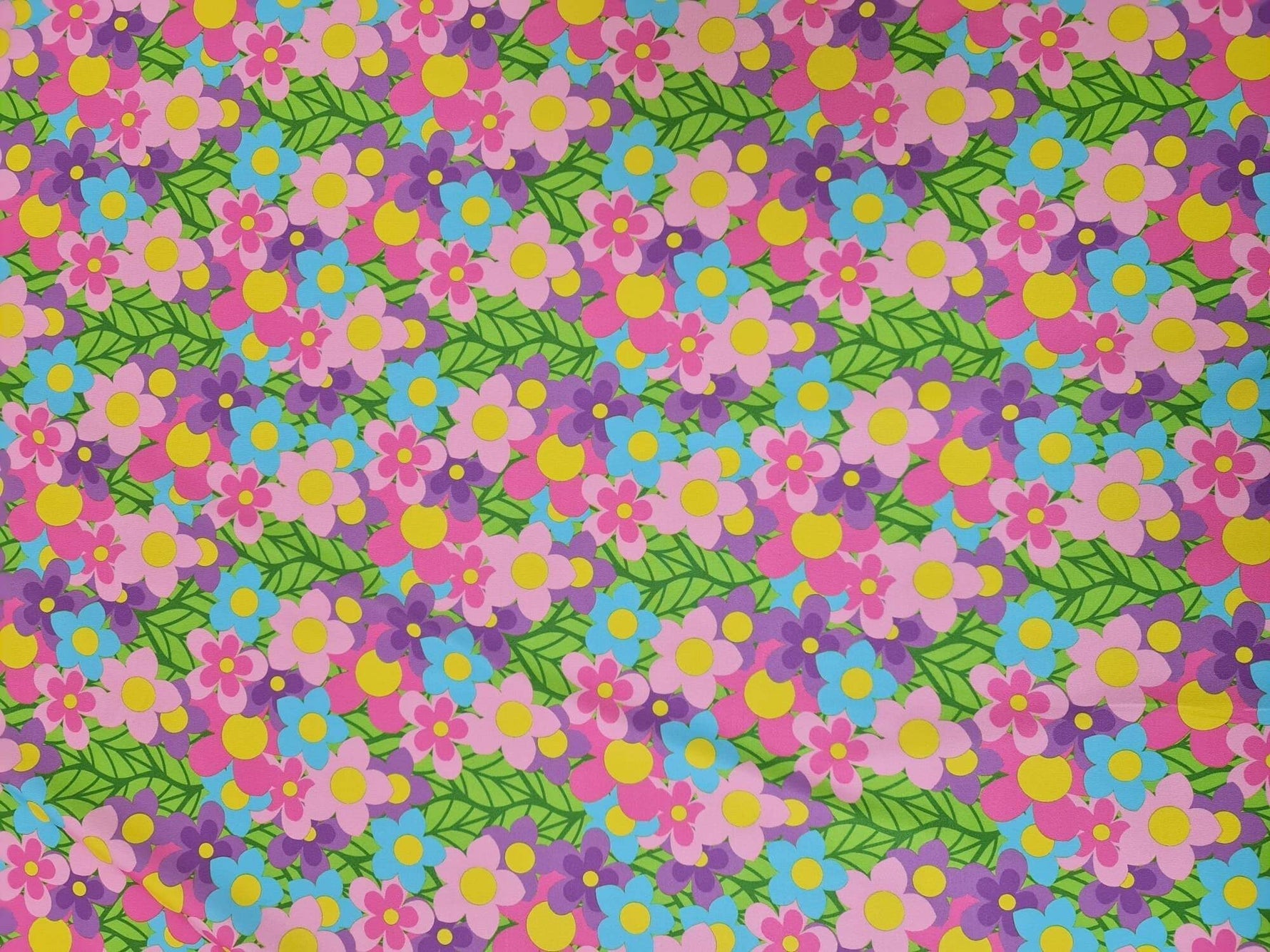 vibrant colorful floral fabric with pink, purple, blue flowers and green leaves pattern