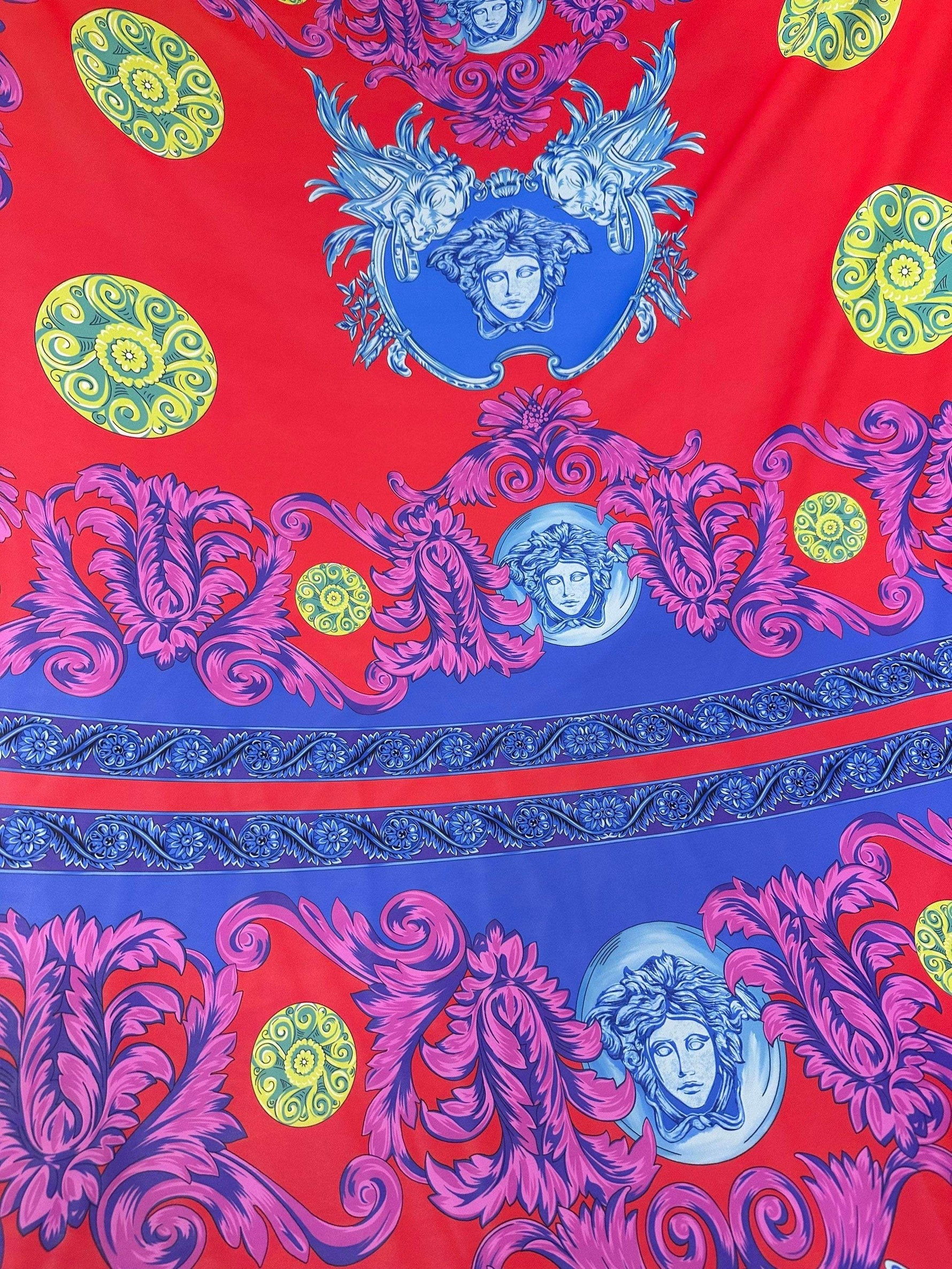 Purple swirl crepe fabric with intricate blue and yellow ornate patterns on red and purple background, lightweight and vibrant design for sewing projects