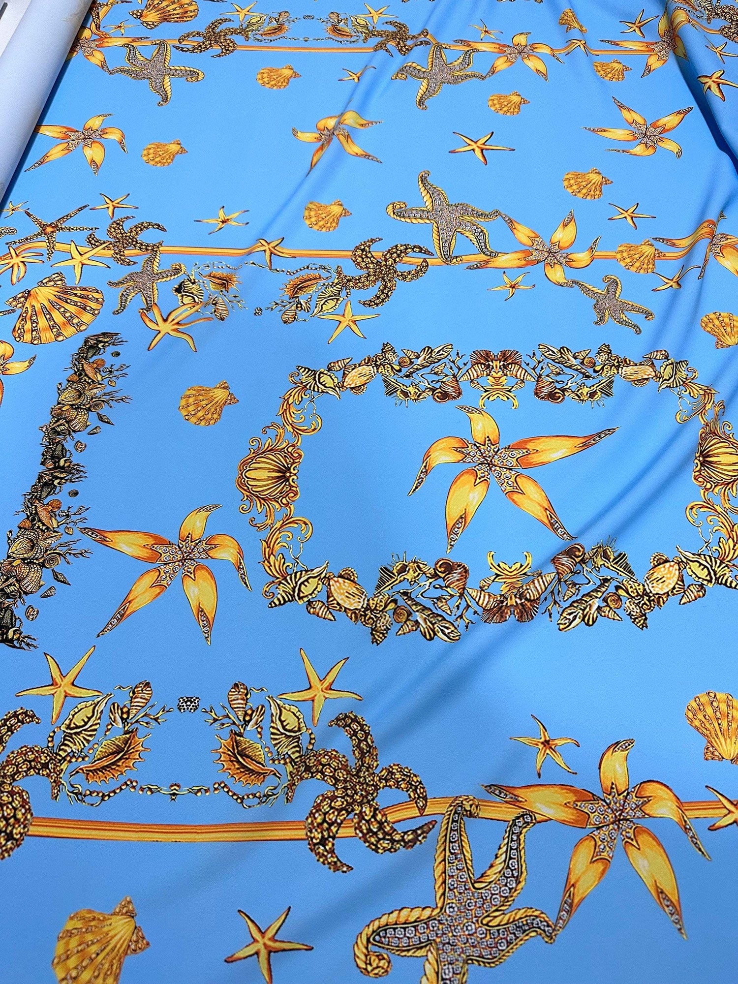 Blue fabric with yellow and brown sea shell and starfish pattern Sea Shell Pattern Fabric