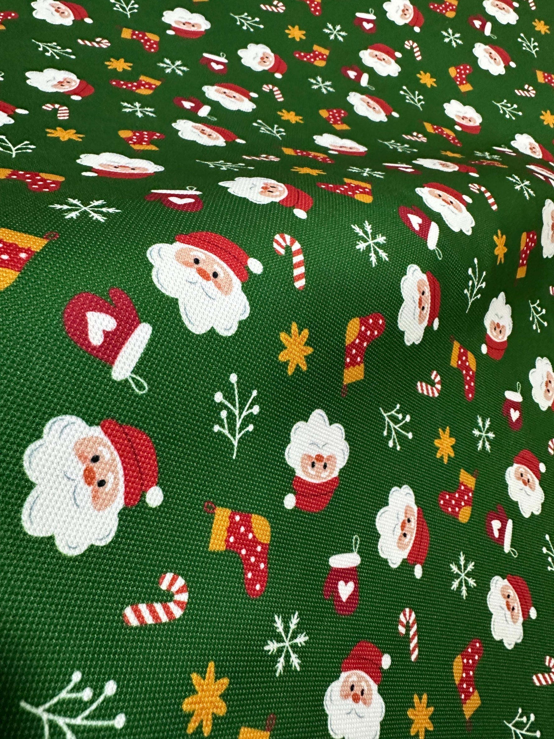 green fabric with repeating cheerful Santa Claus, candy canes, mittens, stockings, and snowflakes pattern for Christmas decoration
