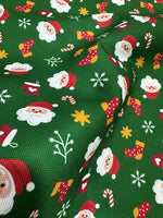 Green Santa Claus fabric with festive holiday patterns on green background for Christmas crafts and upholstery
