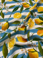 Lemon and floral print fabric with blue and white stripes, featuring lemons, green leaves, and white flowers