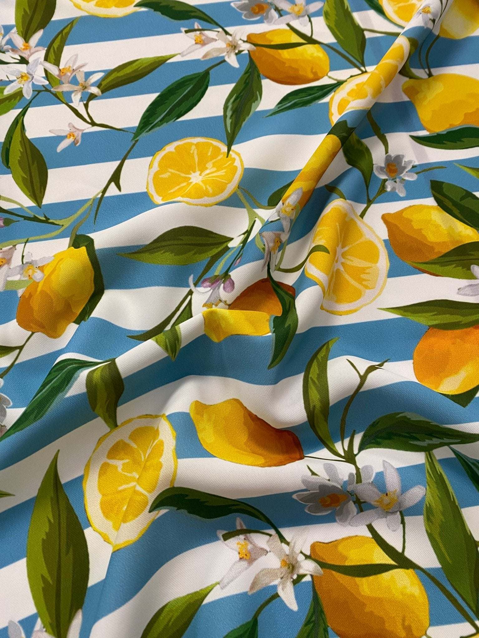 Lemon and floral print fabric with blue and white stripes, featuring lemons, green leaves, and white flowers