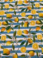 Lemon and floral print fabric on blue and white stripes with green leaves and white blossoms
