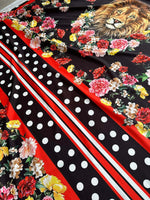 Floral print fabric with colorful flowers, polka dots, stripes, and lion motif on black background