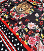 Floral print fabric with vibrant flowers and a detailed lion face on black background, accented with red stripes and white polka dots.