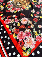 Floral print fabric with vibrant flowers, lion design, red border, and black polka dot background