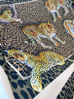 Leopard print crepe fabric with detailed leopard illustrations on a spotted background, ideal for stylish garments and crafts.