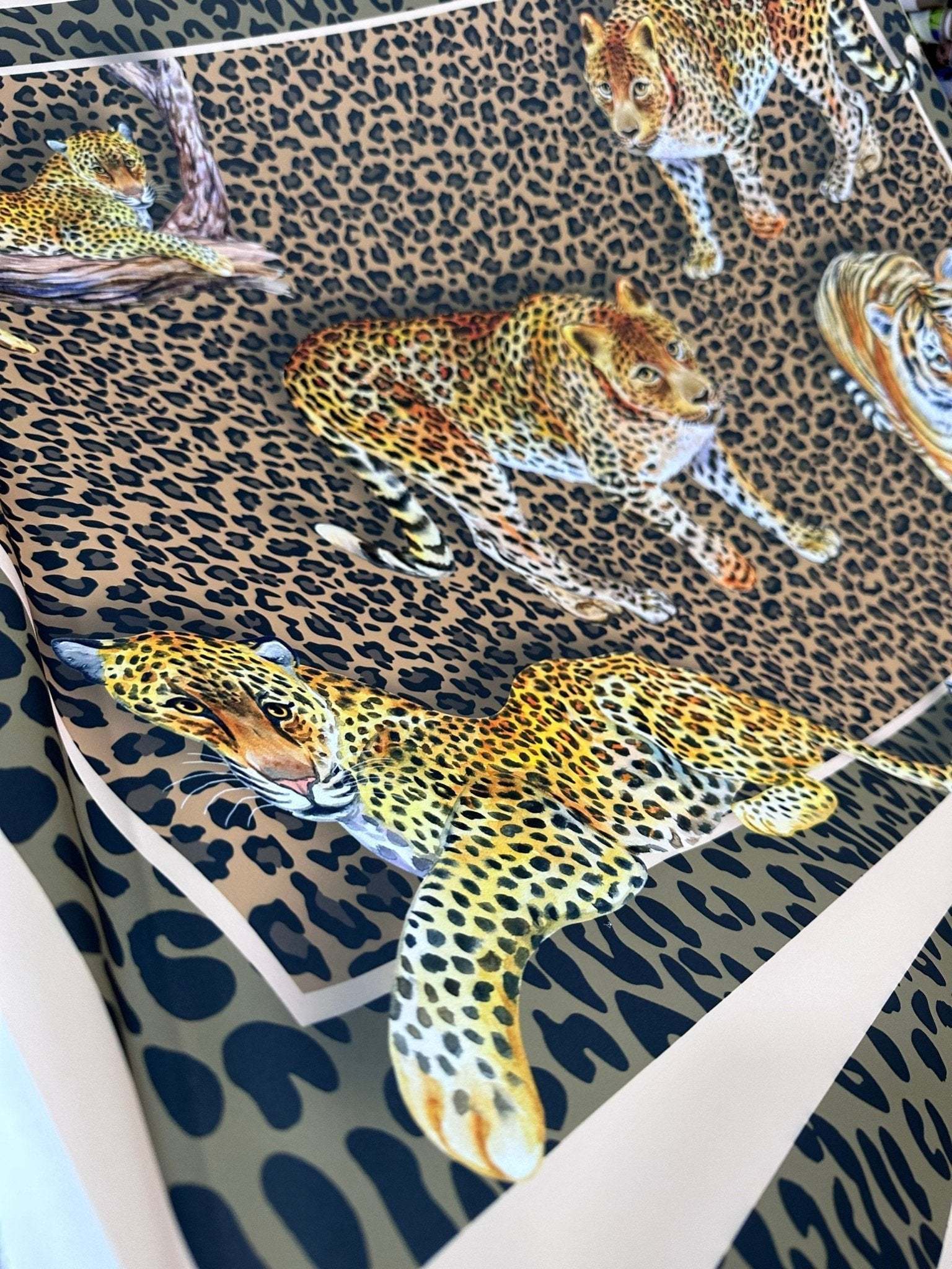 Leopard print crepe fabric with detailed leopard illustrations on a spotted background, ideal for stylish garments and crafts.