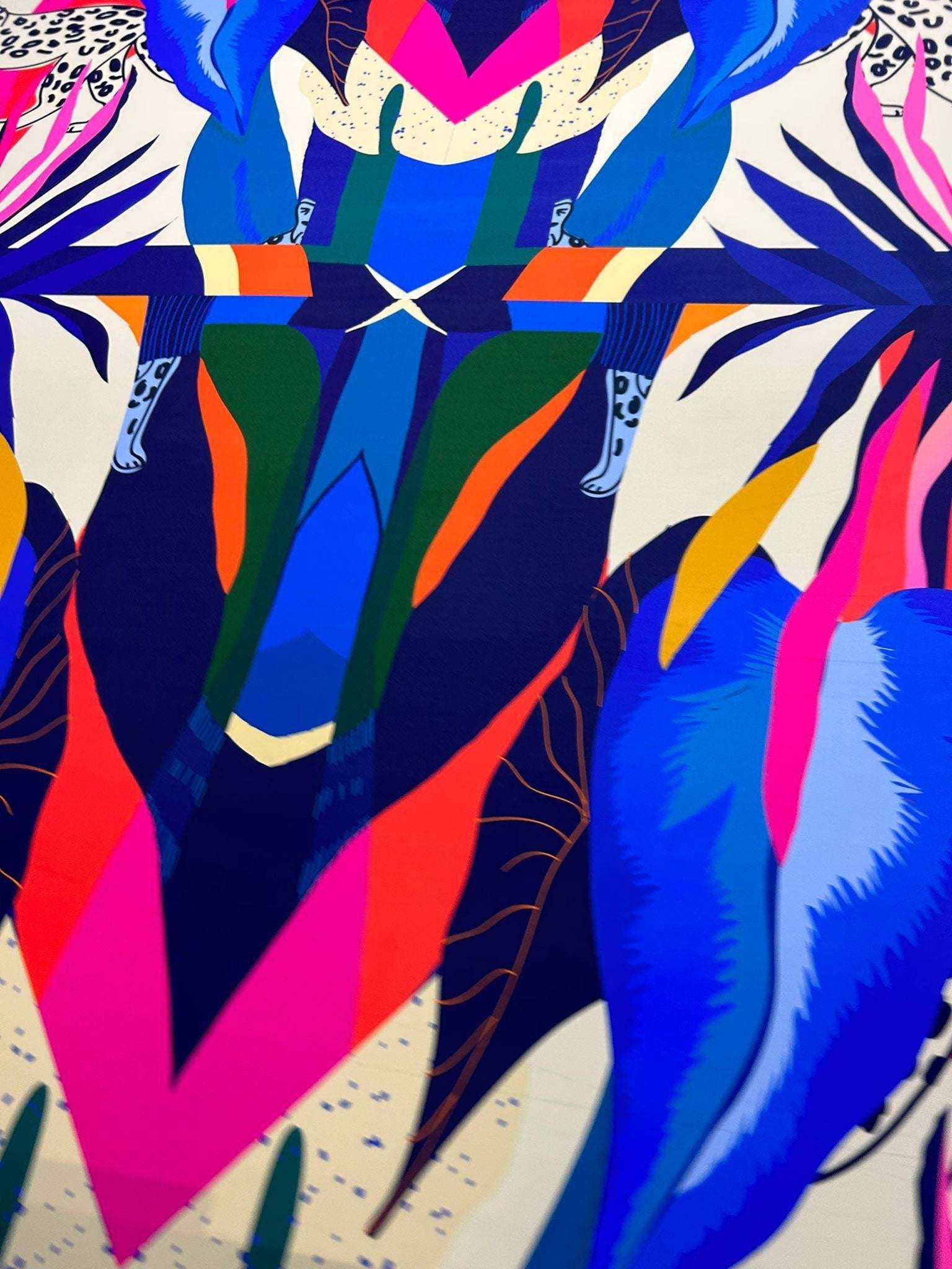 Colorful leopard and tropical pattern fabric with vibrant blue, pink, green, and orange designs on a soft material