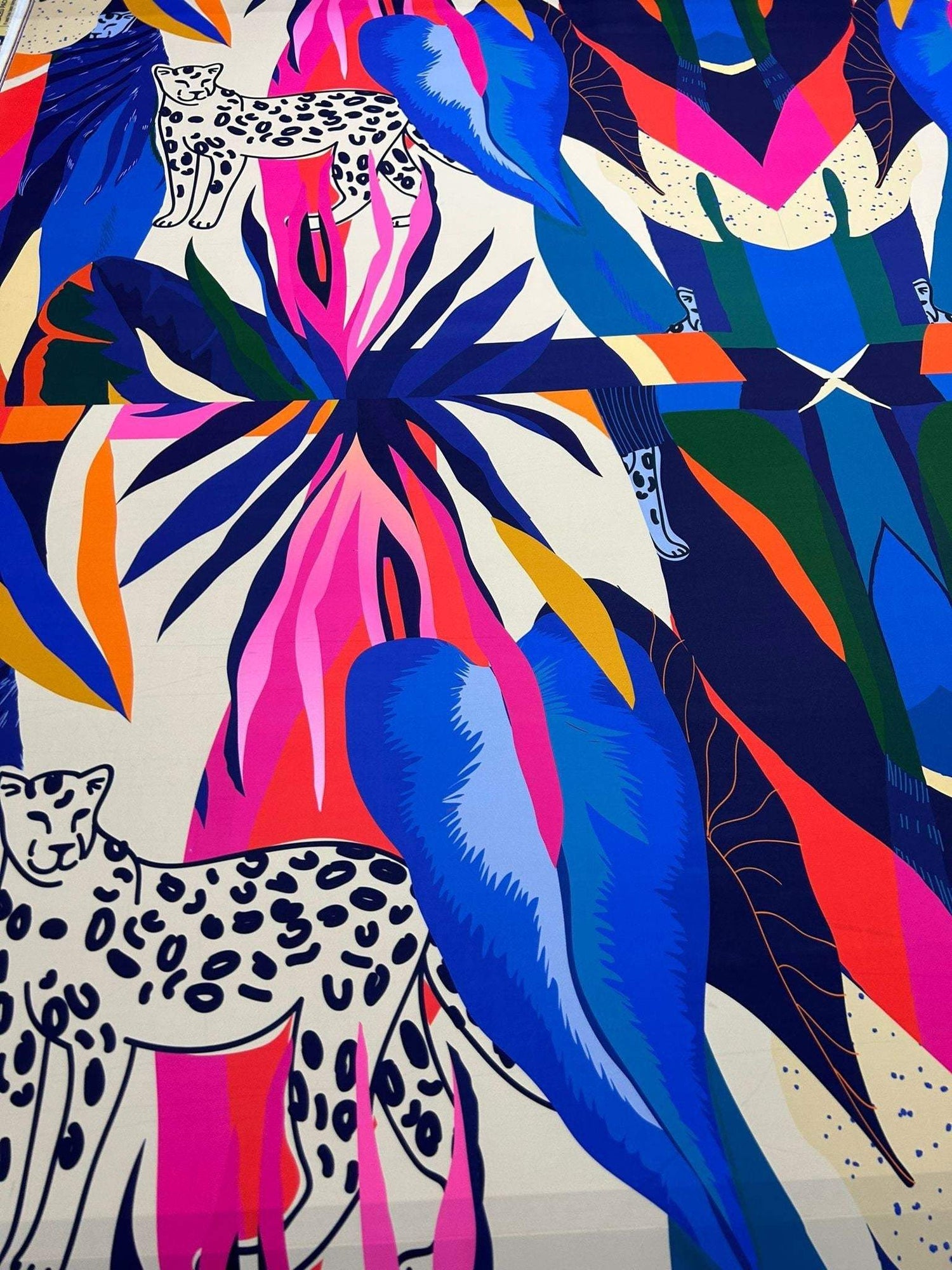Leopard and tropical patterned fabric with vibrant blue, pink, orange, and green leaves and leopard illustrations, 150cm width