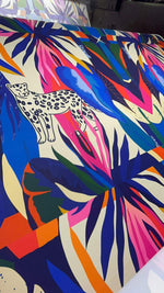 Leopard and tropical pattern fabric with vibrant colorful leaves and a spotted leopard design on soft durable material