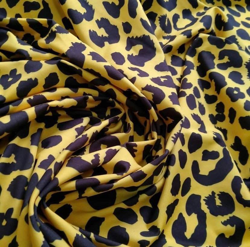 Yellow leopard pattern stretch fabric with black spots in a soft and flexible material