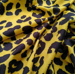 Yellow leopard pattern stretch fabric with black spots and soft texture