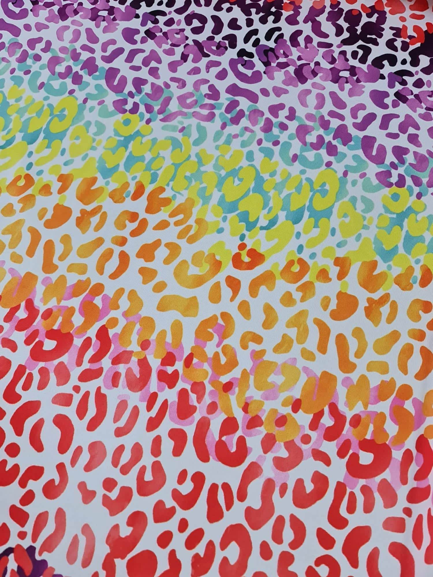 Multicolor leopard print fabric with vibrant red, orange, yellow, green, blue, and purple spots on a white background, fabric width 150cm