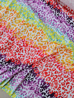 Colorful leopard print fabric with vibrant multicolor animal patterns ideal for sewing projects and accessories