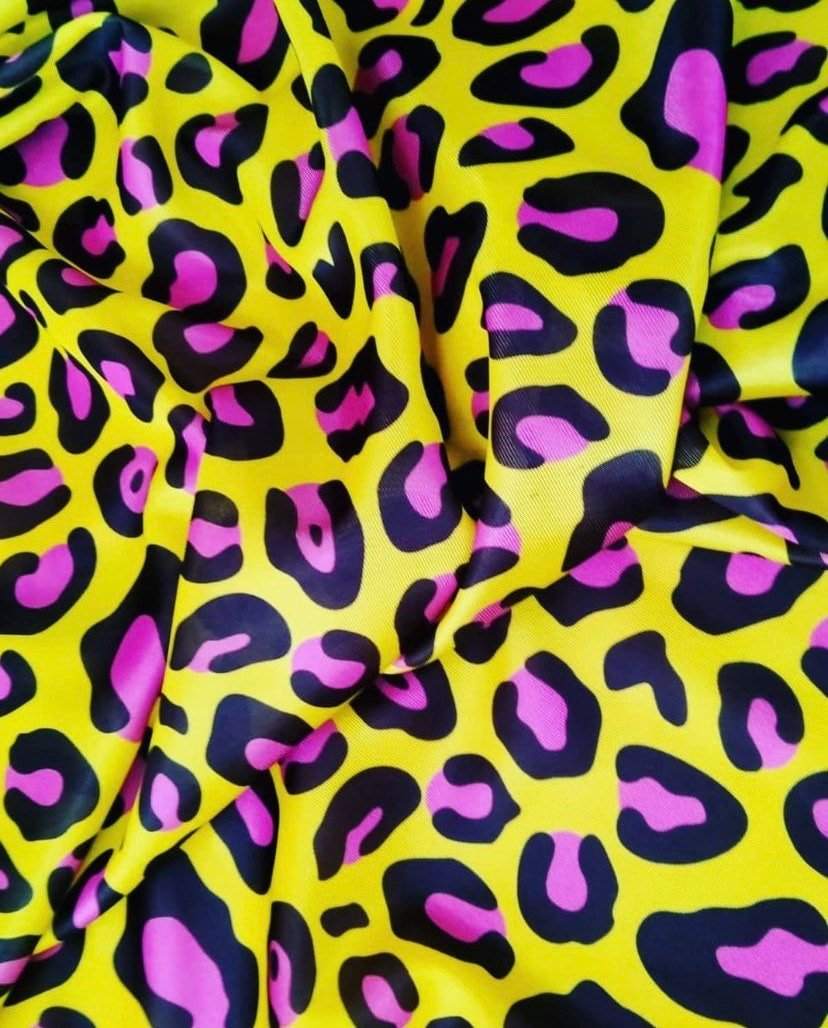 Yellow leopard print fabric with bold black and pink spots for fashion and decor projects