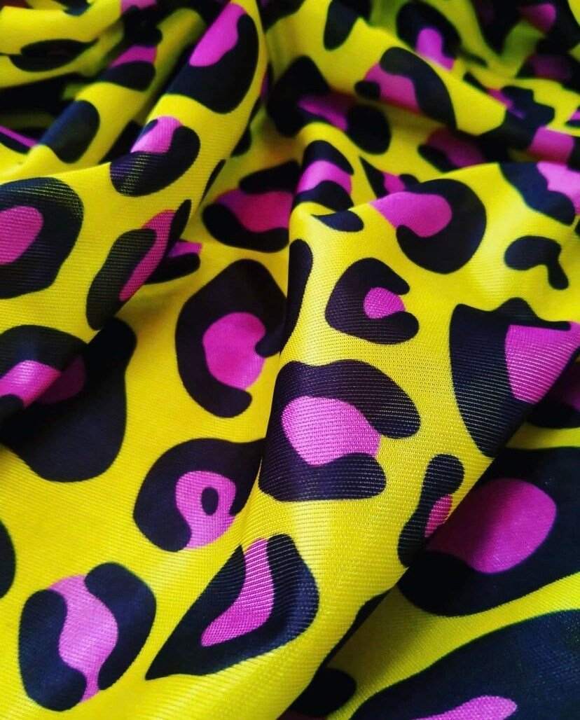 Bright yellow leopard print fabric with bold black and purple animal pattern, soft textured textile for fashion and crafting projects