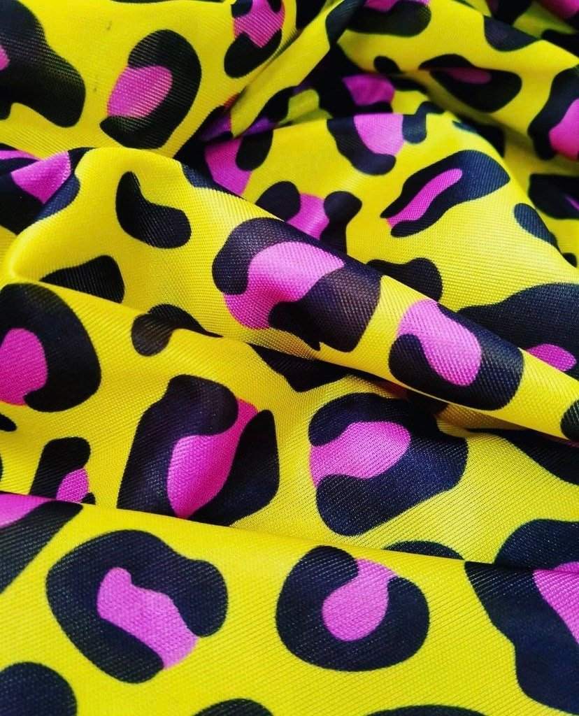 Bold yellow leopard print fabric with black and pink animal pattern, 150cm wide textile for fashion and decor projects