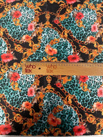 Leopard print fabric with gold chains and red floral accents and ruler for scale