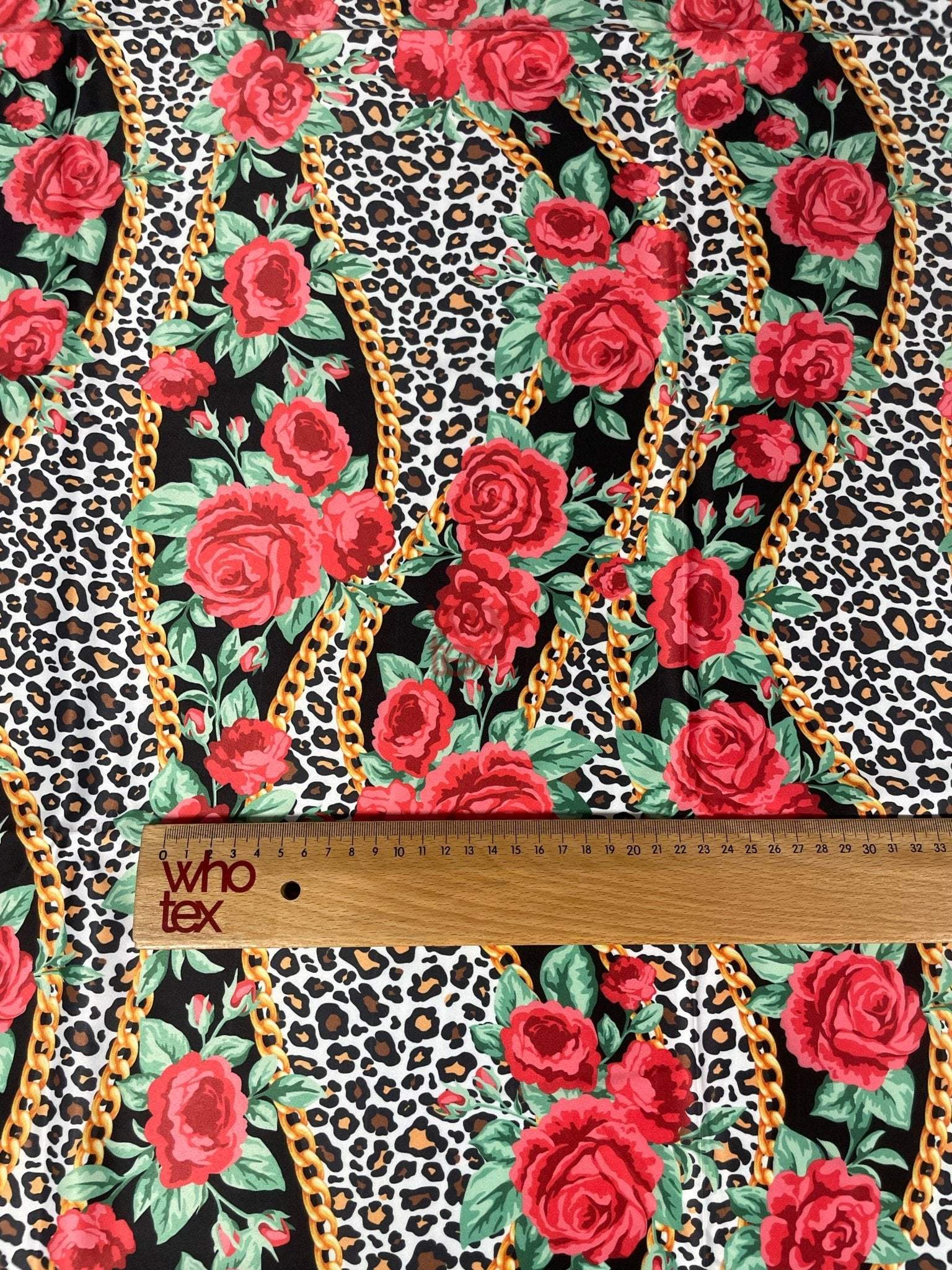 Leopard print fabric with red roses and gold chain patterns and a ruler for scale