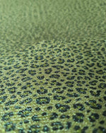 Close-up of shimmering leopard print Lurex fabric with stretch and silky satin finish suitable for activewear and costumes