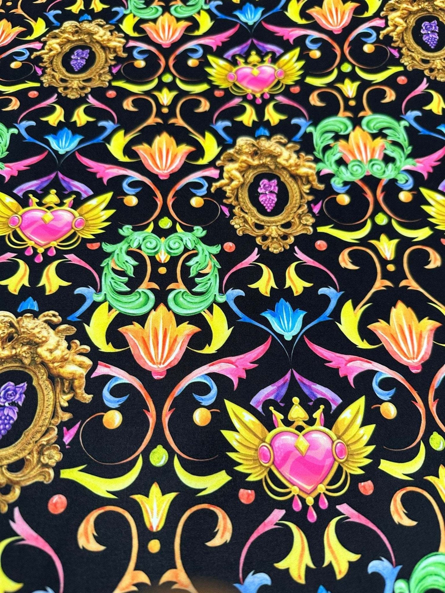 Vibrant black fabric with colorful baroque floral and heart pattern design