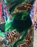 Luxury green leopard print fabric with emerald swirls and exotic animal pattern in a vibrant design