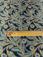 luxury peacock feather fabric with jewel accents and intricate blue and gold patterns on dark background with ruler for scale