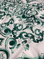 Close-up of green and white Majolica pattern fabric with intricate swirls and floral designs on 150cm wide textile