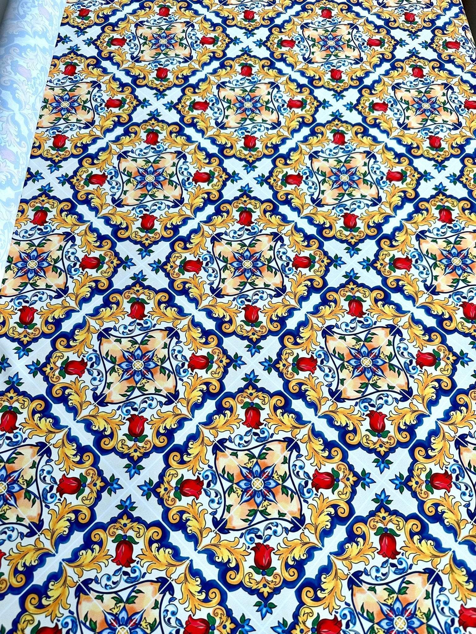 Majolica pattern fabric with vibrant Sicilian print in blue, yellow, and red colors on white background, 150cm wide.