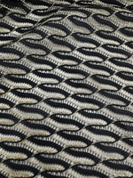 Close-up of black zigzag mesh lace fabric with intricate pattern and texture for elegant fashion designs