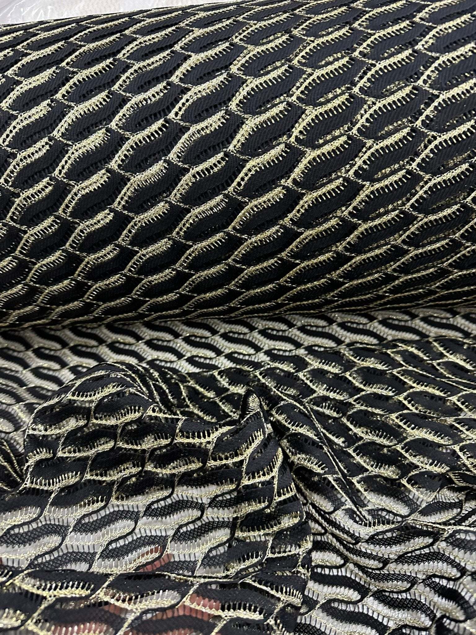 Black zigzag mesh lace fabric with intricate textured pattern for elegant fashion designs