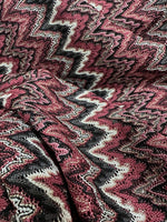 Bordeaux zigzag mesh knit jersey fabric with shiny textured zigzag pattern in burgundy, black, and white tones