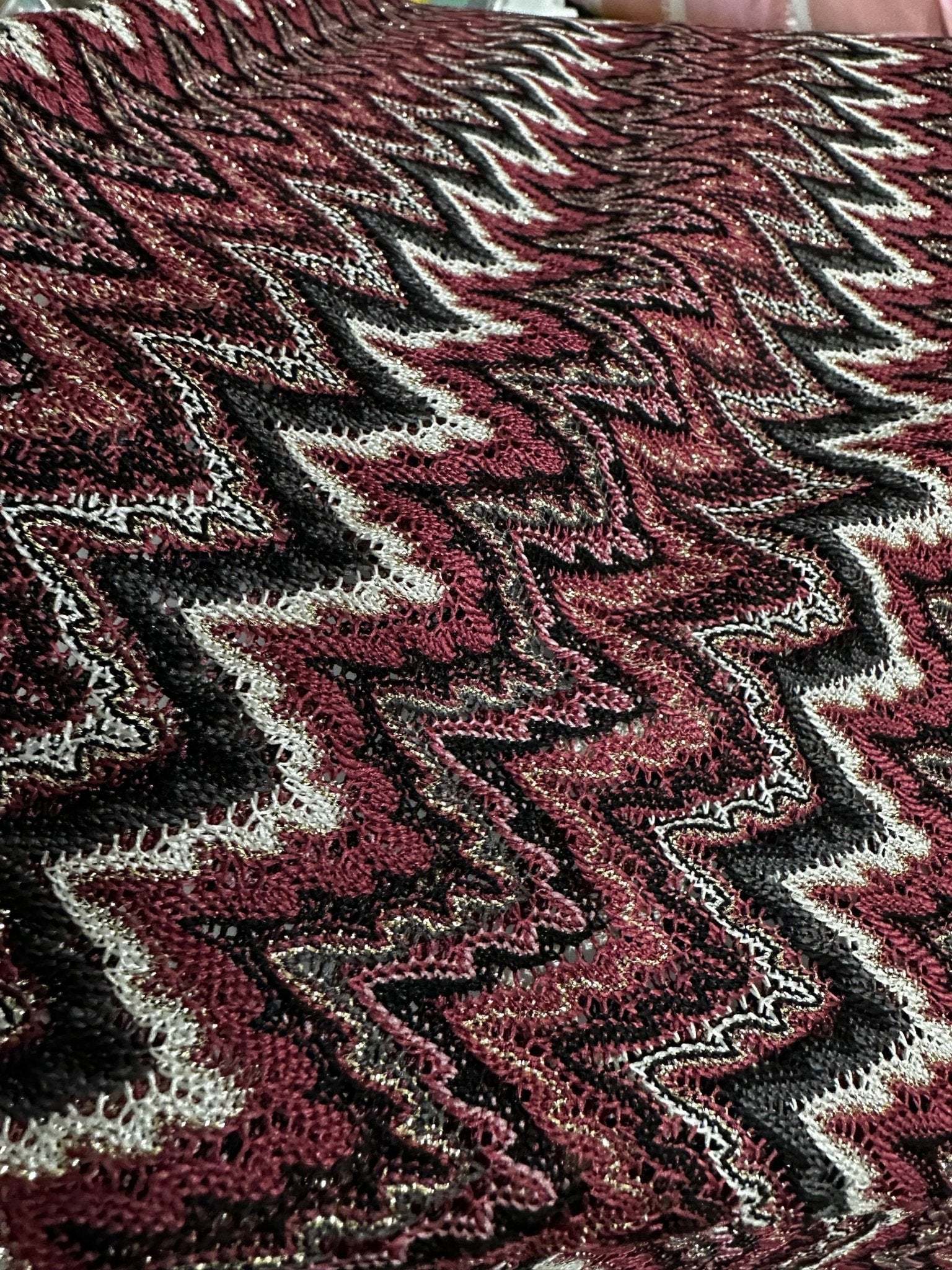 Bordeaux zigzag mesh knit jersey fabric with textured pattern in burgundy, black, and white tones