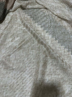 Gray zigzag knit jersey fabric with subtle textured pattern and soft drape