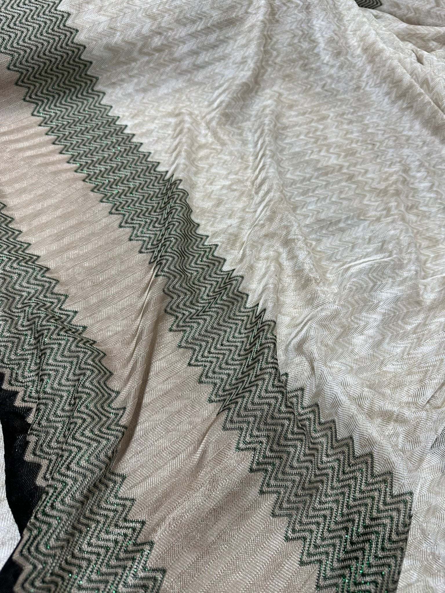 Gray zigzag knit jersey fabric with green glitter breathable mesh material in a continuous length for stylish garments