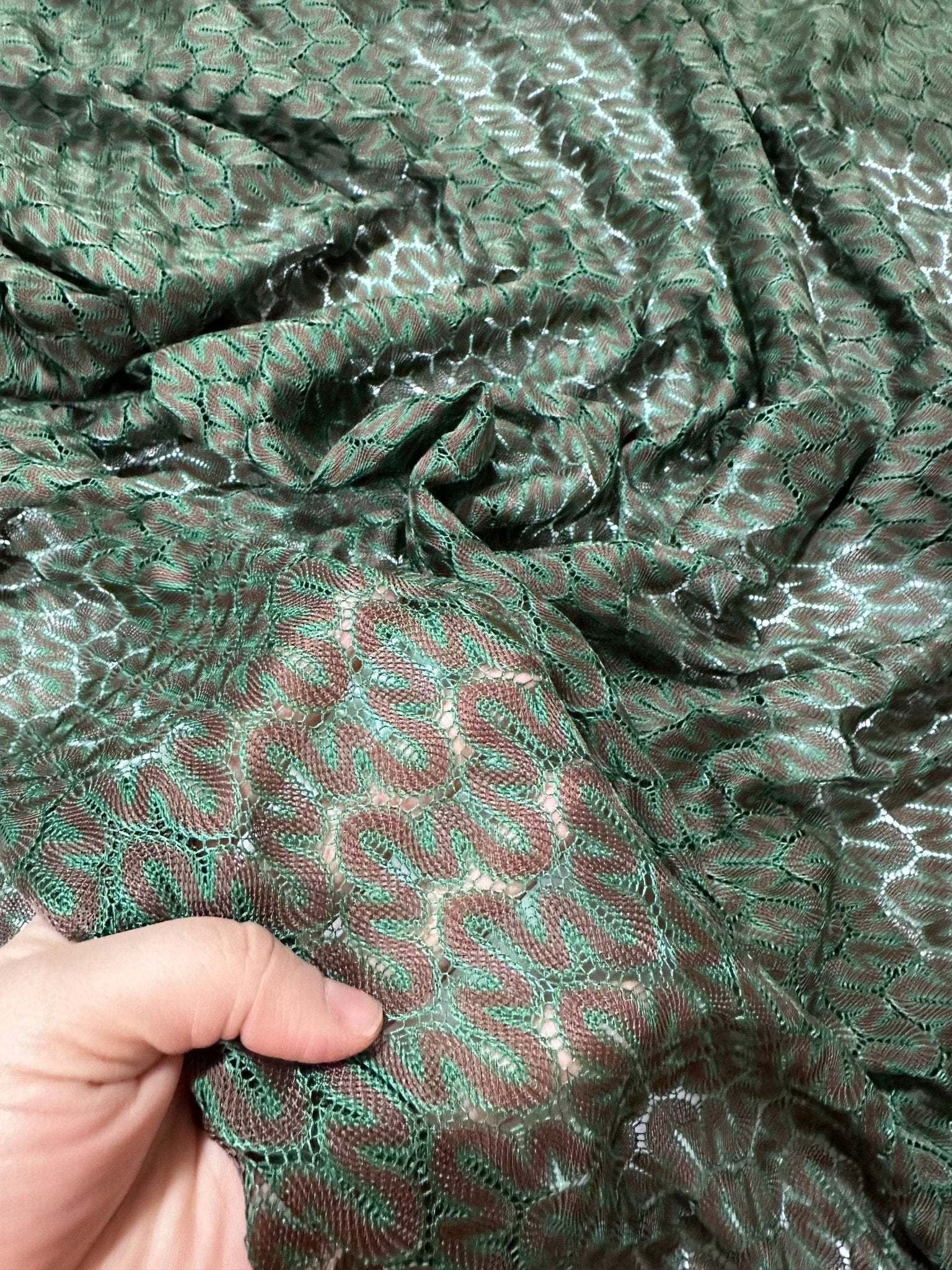 Green and Brown Zigzag Knit Jersey Mesh Fabric with textured zigzag pattern held in hand