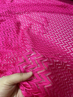 Pink zigzag knit jersey mesh fabric held in hand for crafting and sewing projects