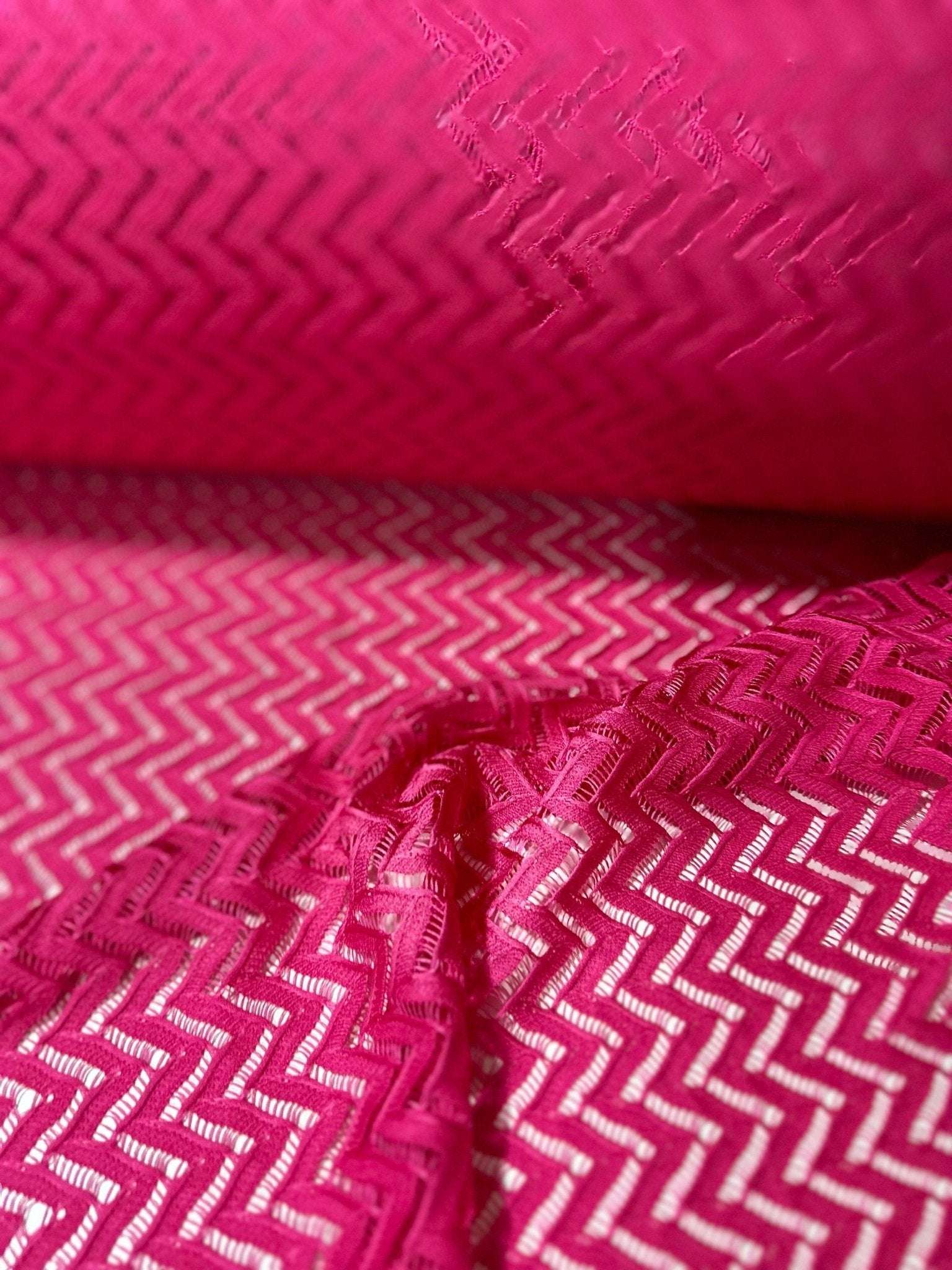Pink zigzag knit jersey fabric with mesh texture for sewing and crafting projects