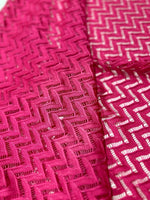 Pink zigzag knit jersey mesh fabric with intricate pattern for crafting and sewing projects