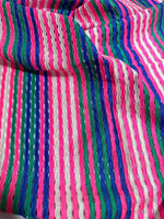 Pink striped knit jersey fabric with textured mesh and vibrant multicolor vertical stripes