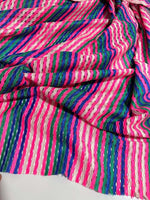 Pink striped knit jersey fabric with soft mesh texture and vibrant multicolor stripes for apparel and crafting projects