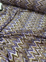 close-up of purple brown zigzag knit jersey mesh fabric with wavy pattern and texture
