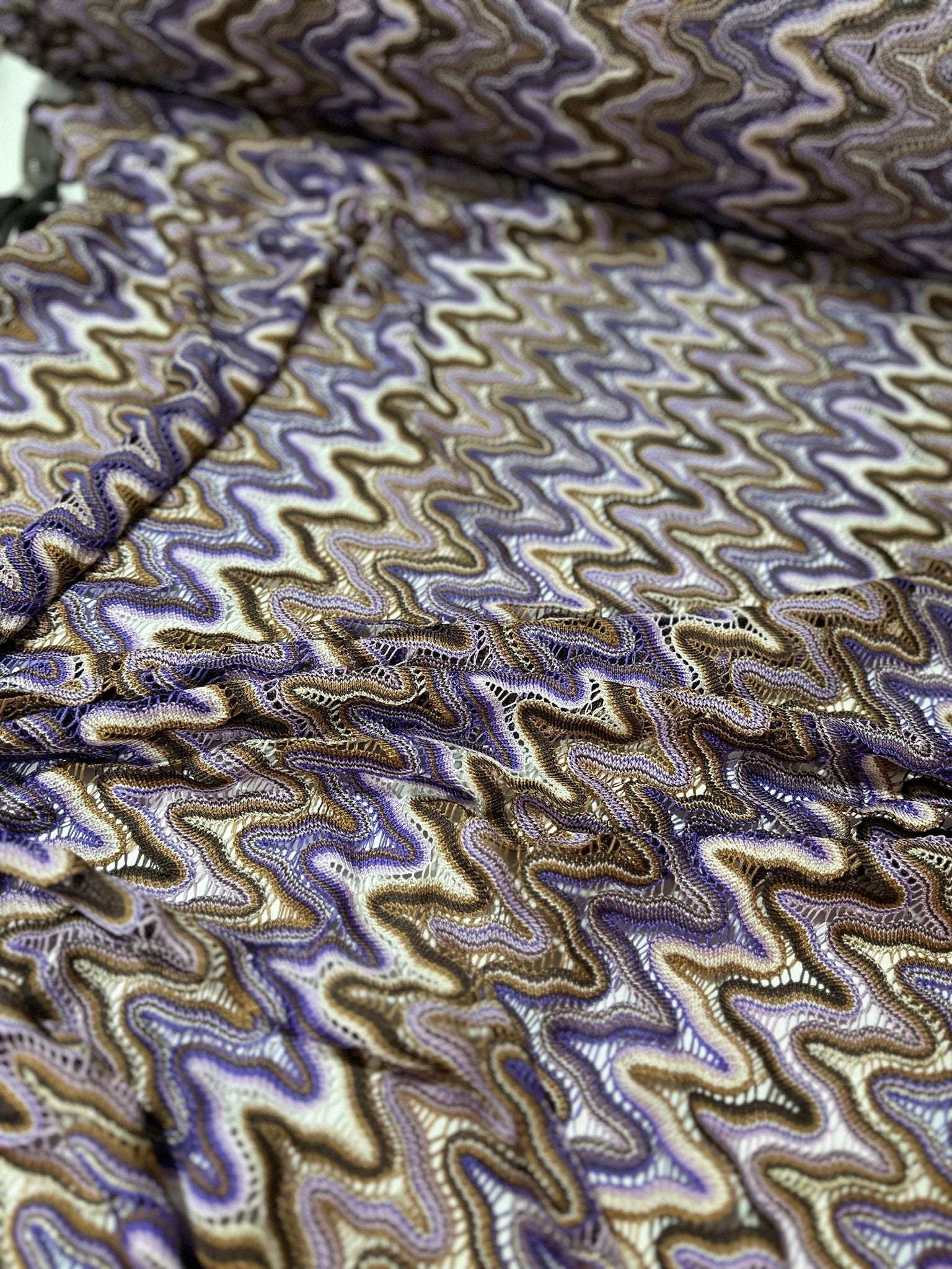 close-up of purple brown zigzag knit jersey mesh fabric with wavy pattern and texture