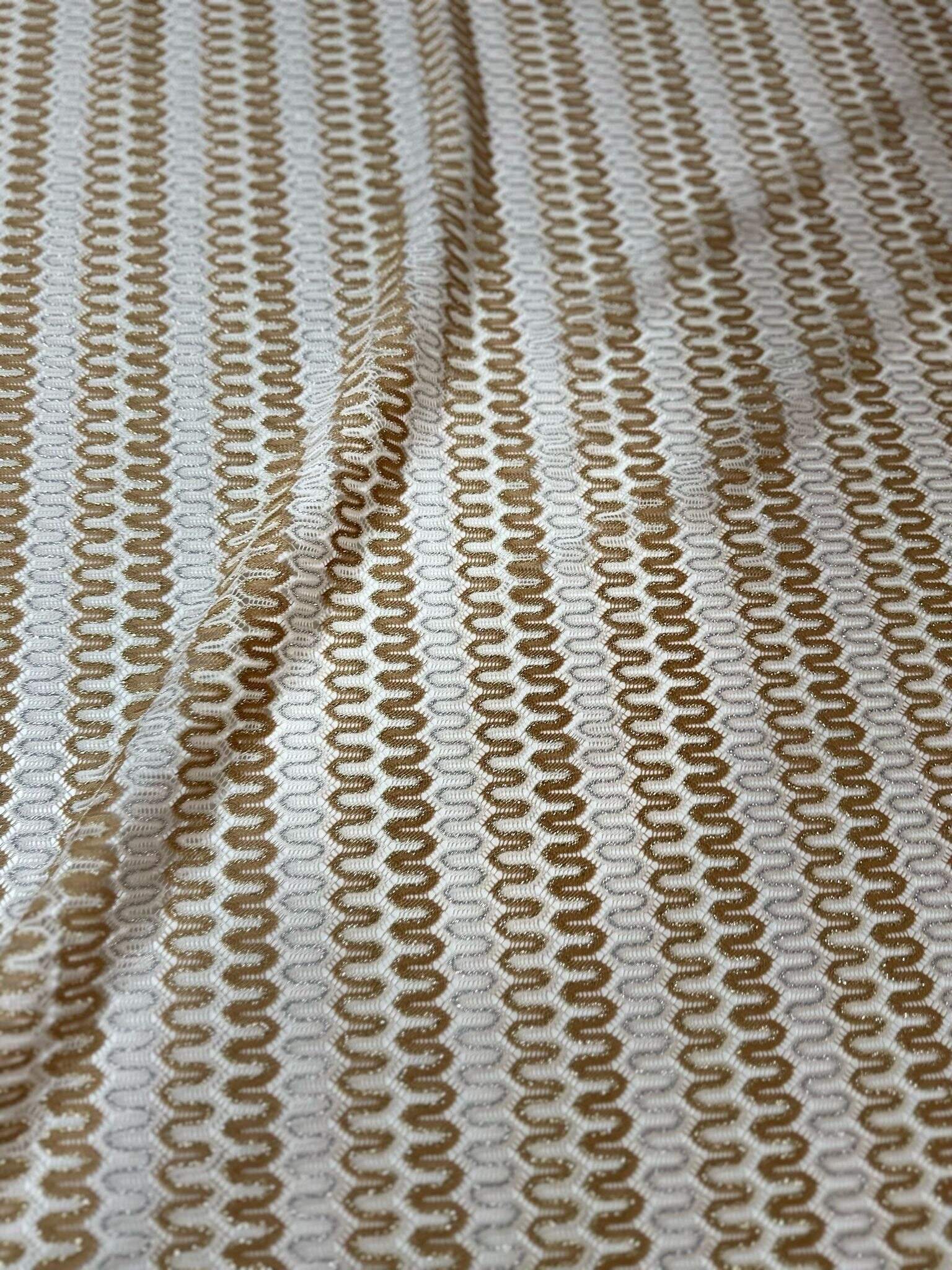 Shimmer zigzag knit jersey fabric in soft beige and cream chevron pattern with a lightweight, breathable texture.