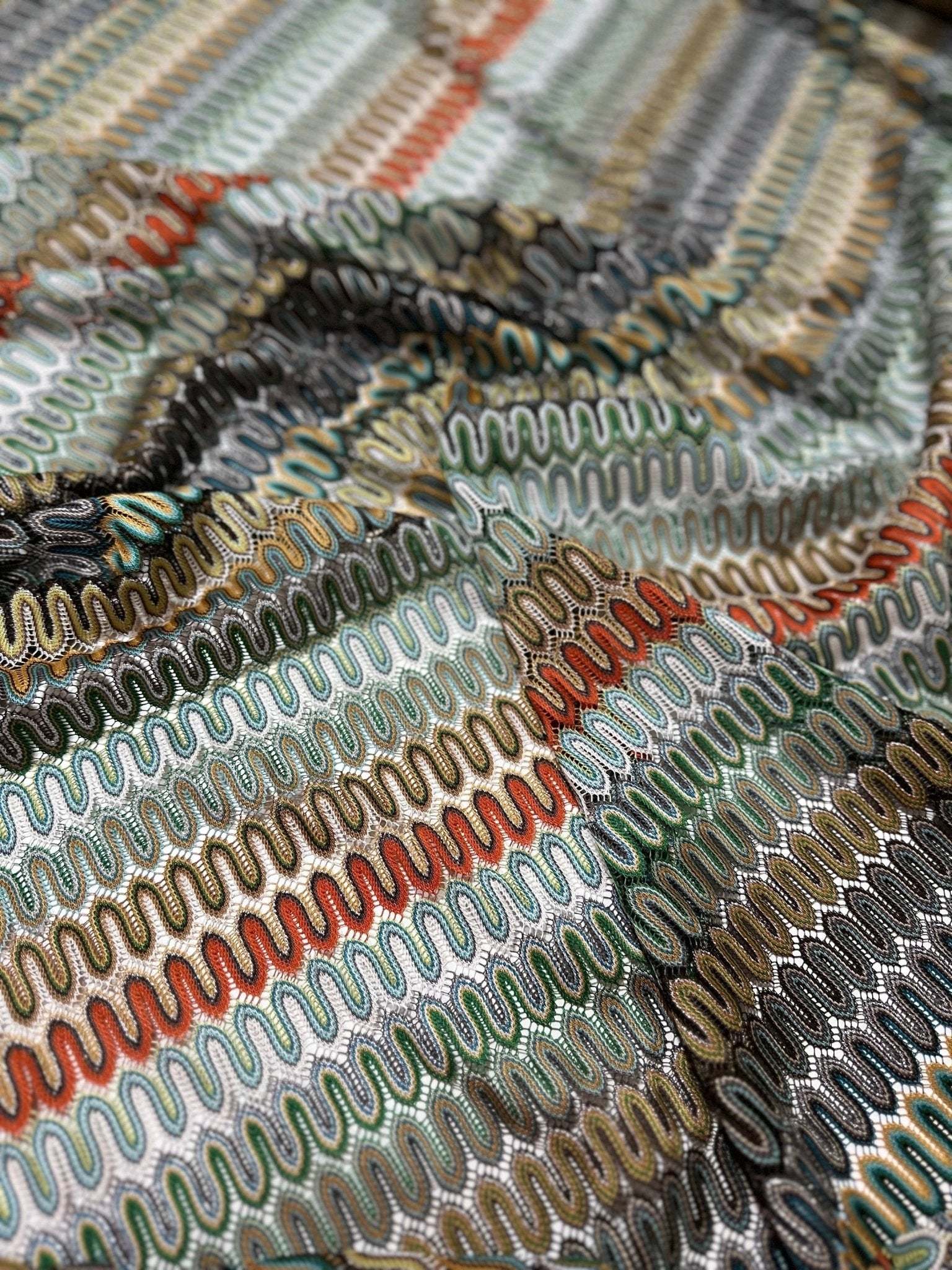 Close-up of colorful Mesh Zigzag Knit jersey fabric with wavy zigzag pattern and soft texture