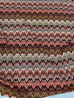 Coral zigzag knit jersey fabric with luxury mesh Italian design in coral, black, white, and gold tones