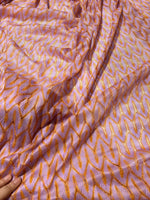 Zigzag knit jersey mesh fabric in lilac and orange with lightweight, soft texture for fashion and crafting projects