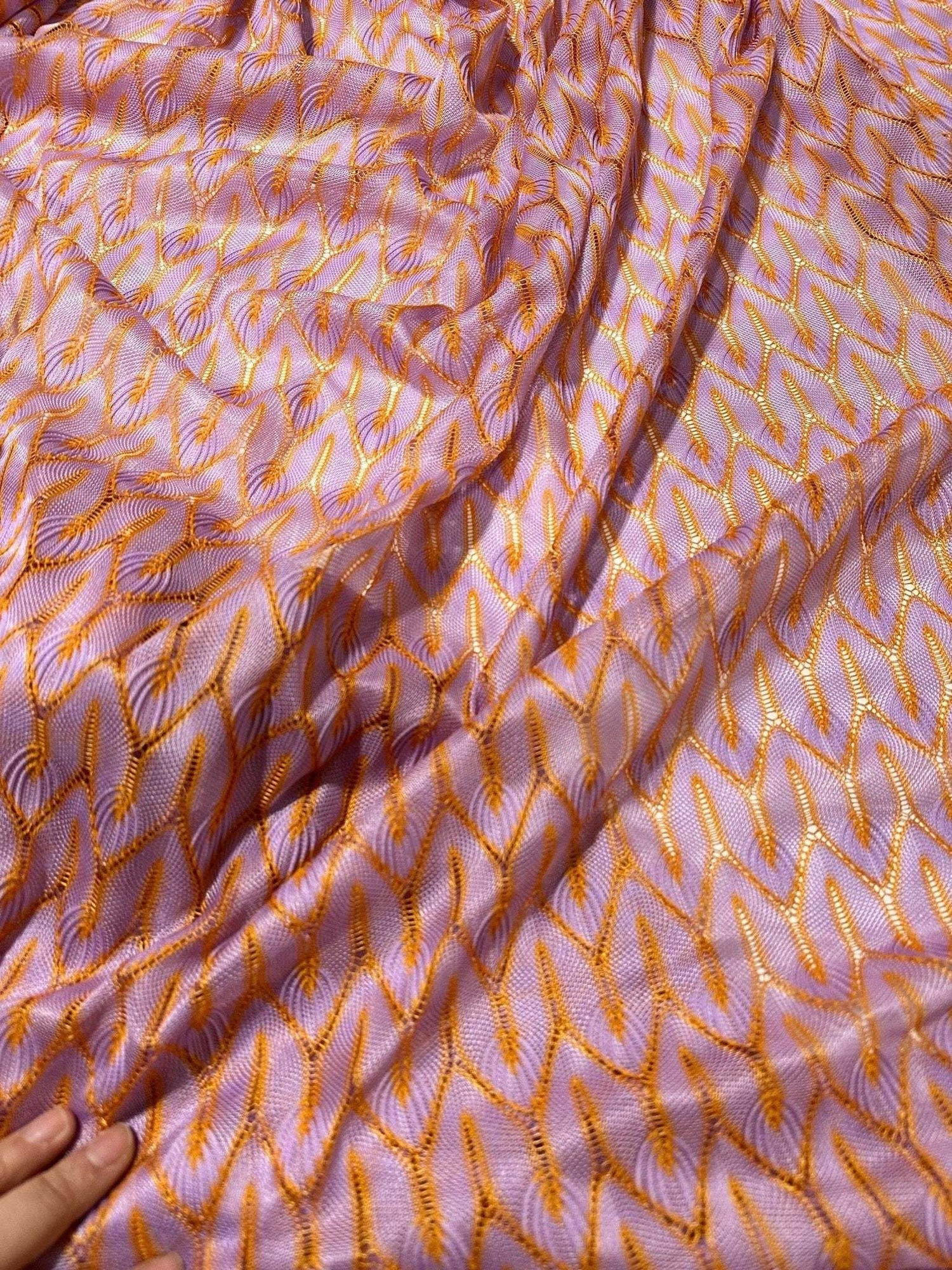 Zigzag knit jersey mesh fabric in lilac and orange with lightweight, soft texture for fashion and crafting projects
